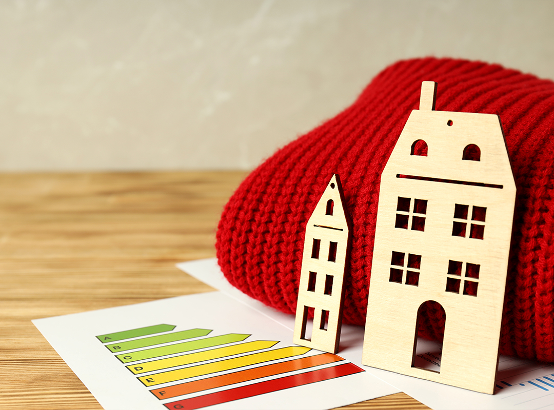 Concept of heating season with red sweater on wooden table